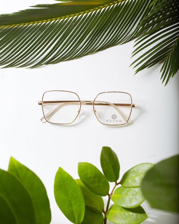 Modern eyeglasses between lush green plant foliage